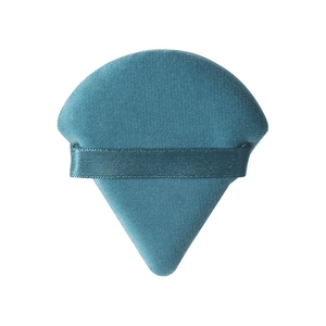 Primer plano de una borla de maquillaje triangular de terciopelo azul con cinta de raso