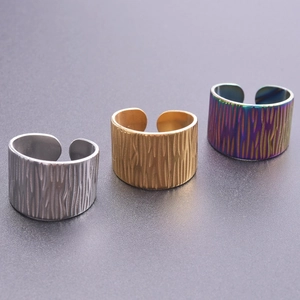 Detail view of adjustable open rings in gold, silver, and rainbow textured steel finish
