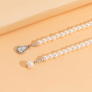 Detail of layered pearl necklace featuring high-gloss beads and teardrop crystal pendant