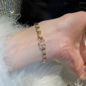 Detail of 18k gold plated heart bracelet with zircon links on a person's wrist