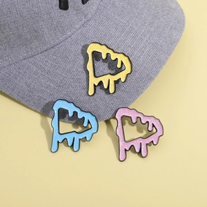 Three colorful melting triangle alloy enamel pins shown on a grey baseball cap background