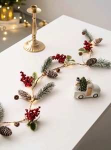 Detail of Christmas garland LED string lights with red berries and natural pine cones