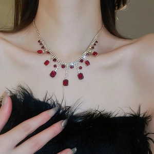 Detail of red square crystals and rhinestones tassel necklace on a model collarbone