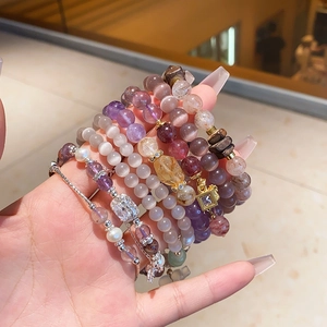 Detail of amethyst and citrine beaded bracelets with zircon accents and pearl charms