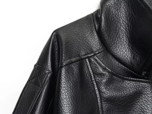 Close-up of black leather jacket shoulders with lychee texture and stitching details
