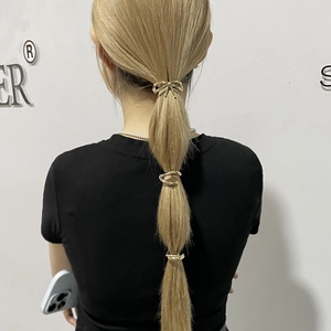 Gold minimalist metal ponytail clip set with bow and rings shown on blonde hair