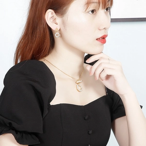 Model wearing gold geometric circular earrings and necklace jewelry set for women