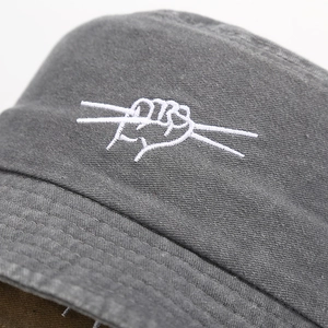 Faded charcoal wash bucket hat featuring white hand gesture embroidery for unisex casual style