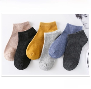 Flat lay of six pairs of colorful cotton boat socks for men in various solid colors