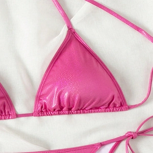 Detailed view of bright metallic pink bikini top with shimmering glitter finish