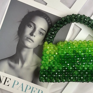 Detail of handcrafted green gradient beaded handbag with transparent textured facets