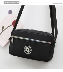 Detail of black nylon crossbody bag featuring vibrant rainbow zippers and sport logo