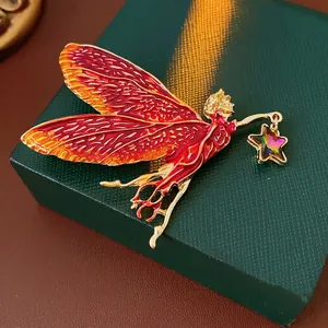Vintage enamel fairy brooch with gold wings and crystal star on a velvet box