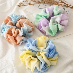 Detailed close-up of three gradient tie-dye chiffon scrunchies in vibrant color palettes