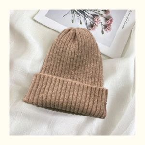 Detailed knit texture of camel wool beanie on aesthetic vintage magazine background