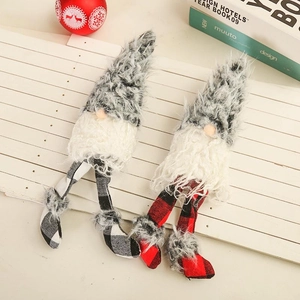 Set of two Christmas long-legged plush gnomes with red and black plaid on wooden surface