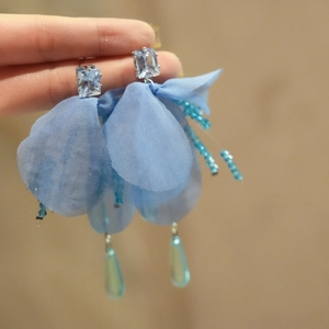 Detalle de los pendientes de flores de gasa azul con circón y colgantes de gota