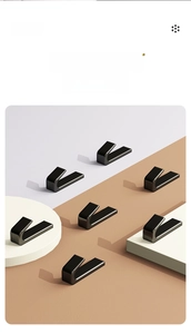 Detail view of a black L-shaped adhesive single hook on a modern minimalist background