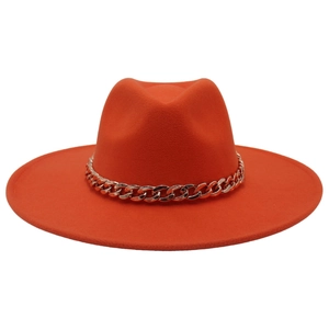 Detail of orange wide brim wool felt fedora hat featuring a chunky gold chain accessory