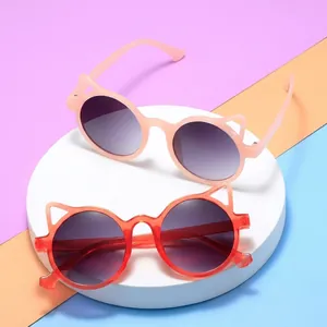 Close-up of cat-ear sunglasses with pink and orange frames and gradient lenses