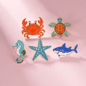 Detail of colorful enamel ocean animal brooches including sea turtle and starfish