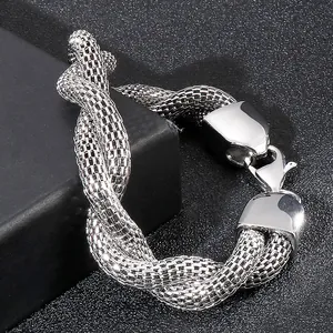 Close-up of silver mesh weave bracelet with lobster clasp on black jewelry box background