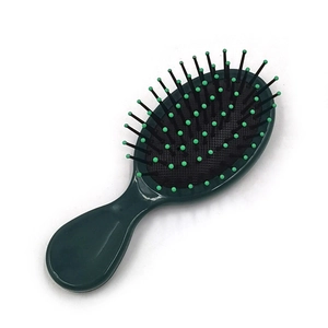 Close-up of green hairbrush showing rounded massage bristles and black cushion base