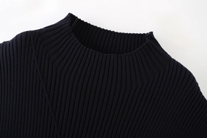 Gros plan sur l'encolure en maille côtelée d'un débardeur noir montrant la texture du tissu