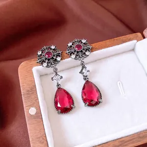 Vintage palace style earrings with pear-shaped red ruby pendants and hollow floral metalwork