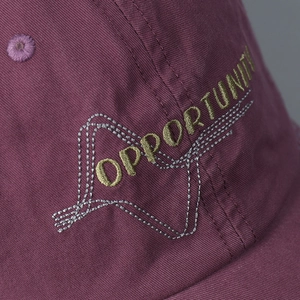 Close-up of washed cotton baseball cap featuring Opportunity letter embroidery