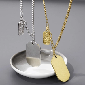 Détail de pendentifs plaques d'identité dorés et argentés avec charmes soleil et étoile