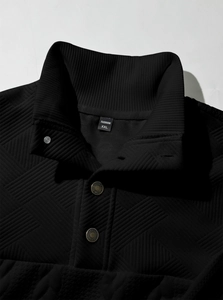 Macro shot of black stand-collar knit pullover with geometric quilting and fashion tag