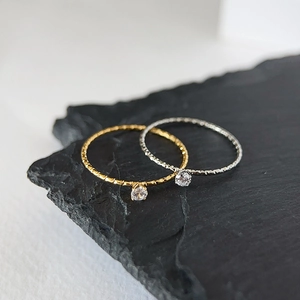 Minimalist 18k gold and silver plated sparkle rings set on black slate background