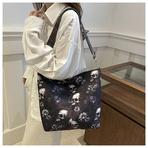 Detail view of nylon bucket bag featuring skull floral print and wide crossbody strap