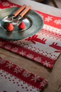 Close-up of knitted Christmas table runner featuring elk and snowflake patterns on wood