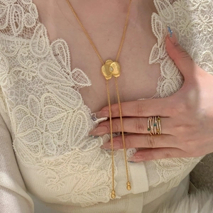 Détail du collier fleur plaqué or 18k avec zircone cubique sur dentelle blanche