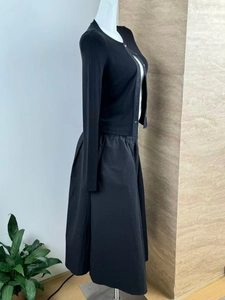 Detail of black knit cardigan and woven midi skirt set on mannequin