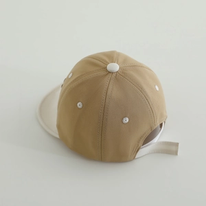 Top view of two-tone khaki and white baby baseball cap showing seams and vent details