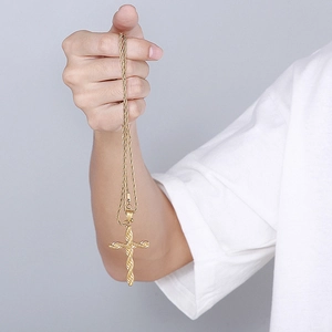 Nahaufnahme einer goldenen Kreuzkette aus Edelstahl mit gedrehtem Anhänger und Kordelkette