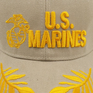 Macro detail of U.S. MARINES 3D embroidery and golden oak leaf on khaki cotton twill hat