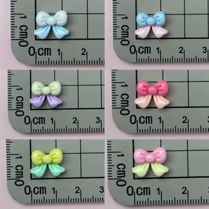 Macro view of 1.5cm mini resin four-point star bows in various pastel candy colors