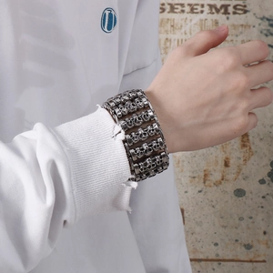 Macro detail of multi-row skull link bracelet in vintage punk style on male wrist