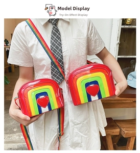 Detail of colorful rainbow heart crossbody bag in glossy patent leather with wide strap