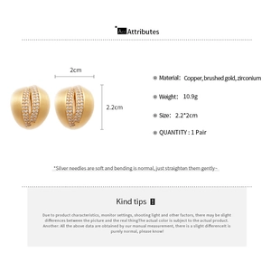 Detail view of 18K brushed gold C-shaped earrings with zircon inlay and silver pins