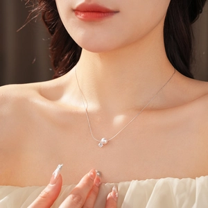 Gros plan détaillé d'un collier en argent avec perle blanche et zircon porté par un mannequin