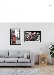 Modern black minimalist photo frames displayed on a white wall above a cozy sofa setup