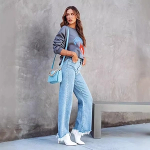 Vaqueros de cintura alta y pernera ancha para mujer con sudadera gris y bolso de cadena