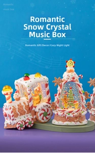 Close-up of gingerbread train and tree music boxes with glowing night light and snow effect