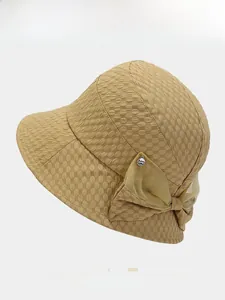 Detail of khaki bucket hat with unique bubble texture and elegant organza bow