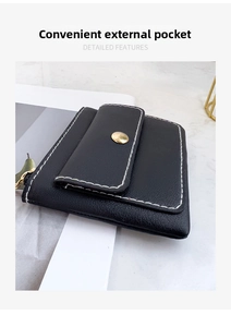 Detailed close-up of black pebble leather coin purse with white contrast stitching